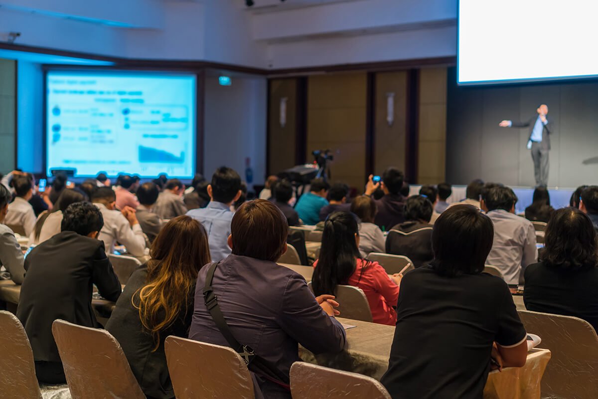 Audience at a live event listening to professional audio speakers on stage