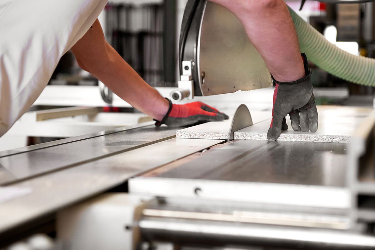 Carpenter cutting wooden panel for OEM speaker cabinet manufacturing at Ezcom Electronics